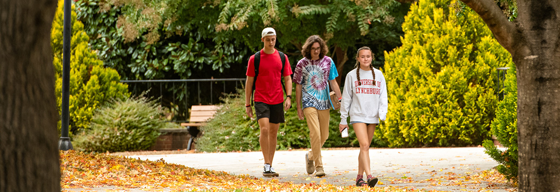 Three students walking on campus.