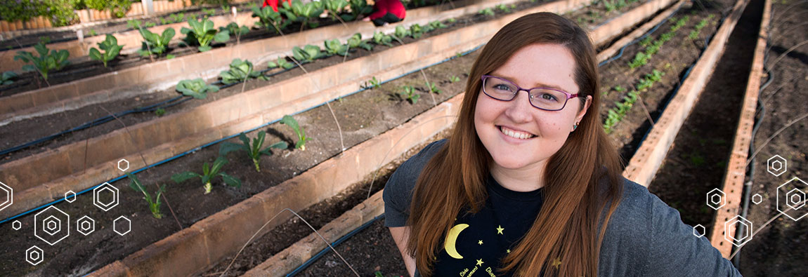 A University of Lynchburg Master of Arts in Nonprofit Leadership Studies (MA) student standing in a greenhouse